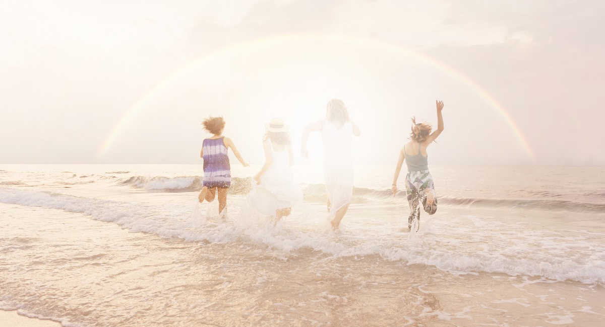 happiness. 4 people frolicking in the ocean